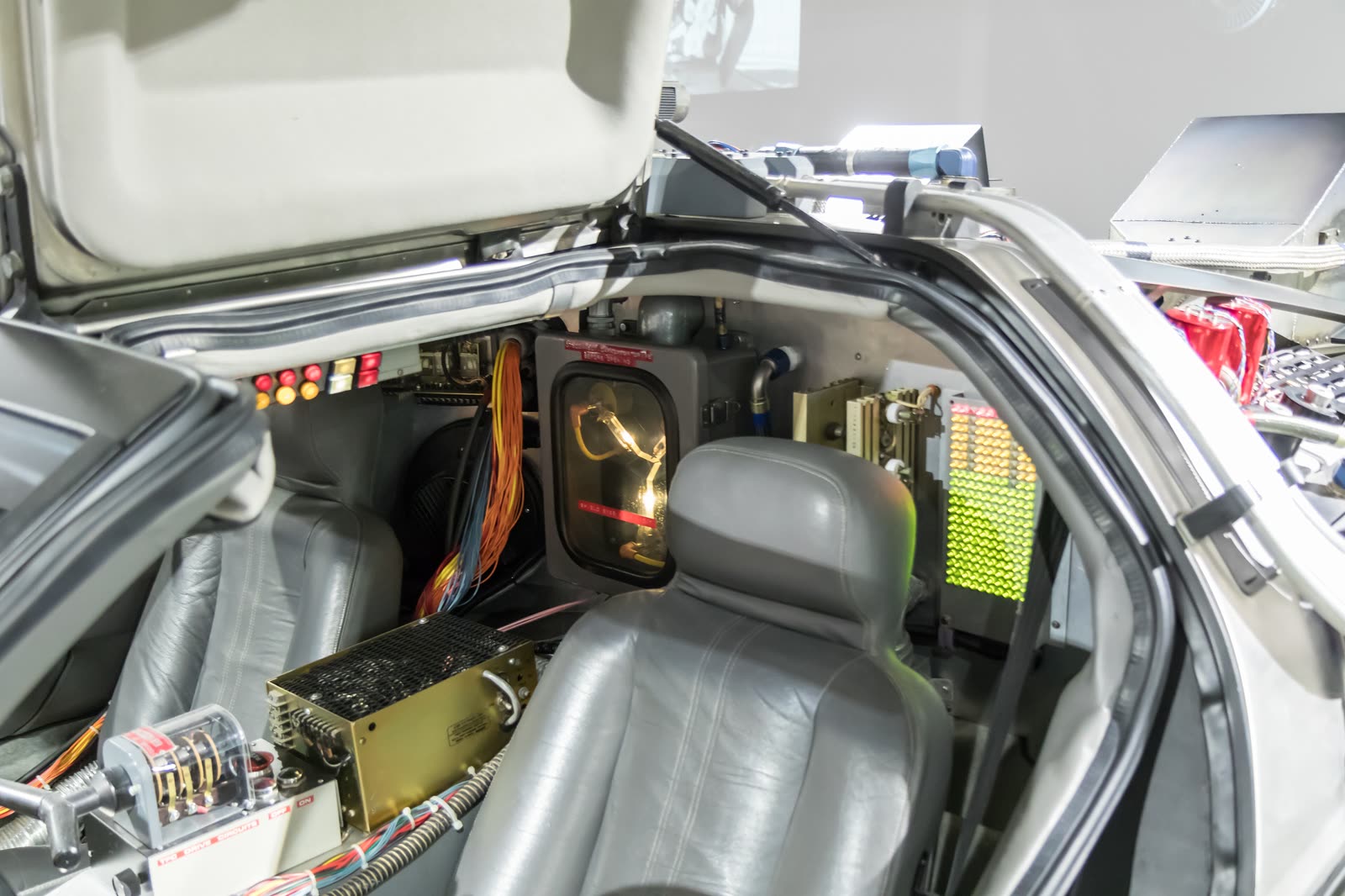 The glowing Y-shaped flux capacitor prop behind the seats of a DeLorean time machine