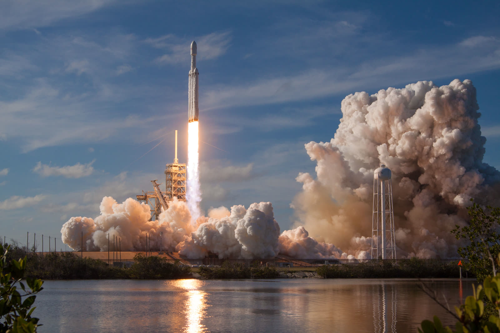 Falcon Heavy rocket lifting off, seen across the water